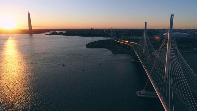 一座斜拉桥在夕阳下的城市背景上视频素材