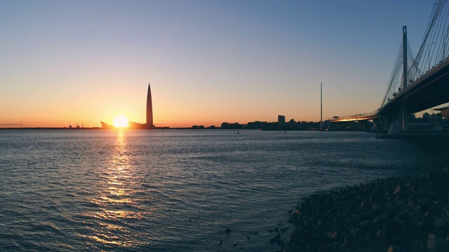 一座斜拉桥在夕阳下的城市背景上视频素材