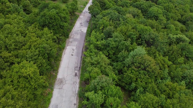 飞过森林里修葺过的乡村公路。空中无人机视图视频素材