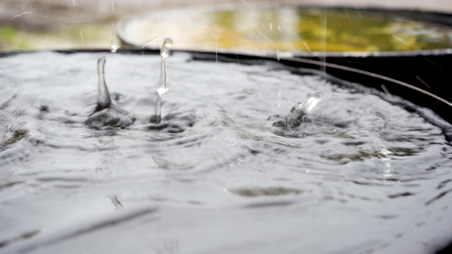 雨点落在屋外的大桶上视频素材