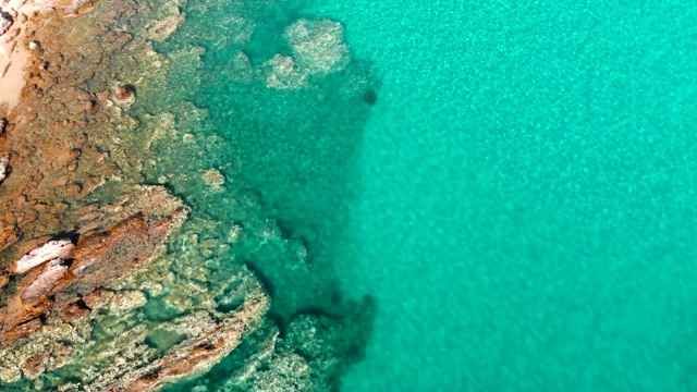 鸟瞰图美丽的海滩上的希腊岛，岩石海岸与绿松石海视频素材