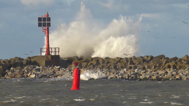 在暴雨中海浪击打混凝土防波堤海岸和灯塔的慢动作视频素材