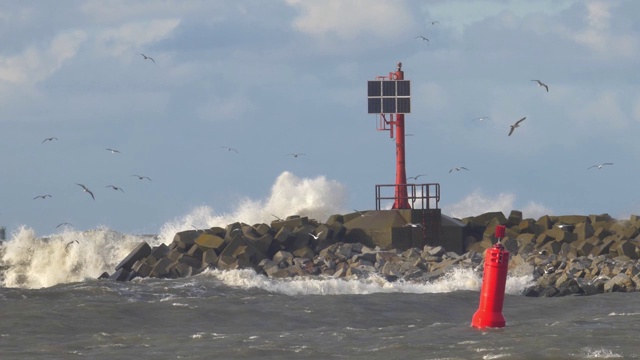 在暴雨中海浪击打混凝土防波堤海岸和灯塔的慢动作视频素材