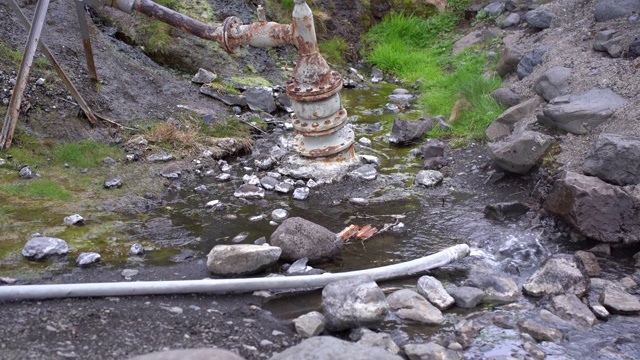 旧的管道堵塞了管道。水从岩石下面涌出。视频素材