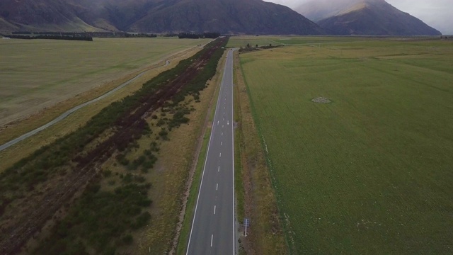 鸟瞰图，两车道公路之间美丽的农田，多云的天空，新西兰视频素材