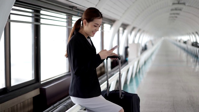 女乘客在机场用智能手机等待航空旅行视频素材