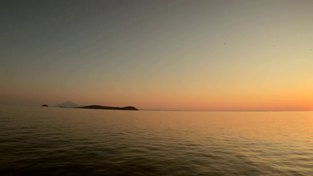 在夕阳西下的爱琴海上航行，从希腊岛上的游轮上看到美丽的景色视频素材