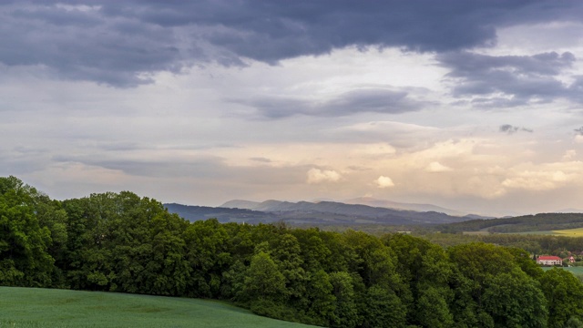 在一个下雨的早晨，捷克共和国Hranice na Morave，夕阳在一个充满橙色山丘的山地上改变了周围的城镇和房屋的景观视频素材