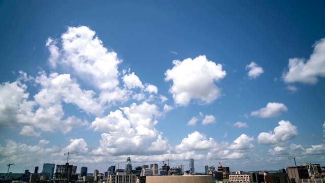 在奥斯汀德克萨斯天际线的蓝色天空上的多朵云的广角时间流逝视频素材