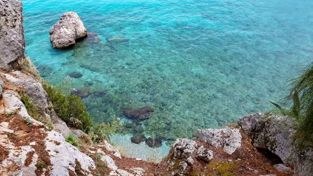 鸟瞰图透明的海水与岩石底部悬崖在早晨的阳光视频素材