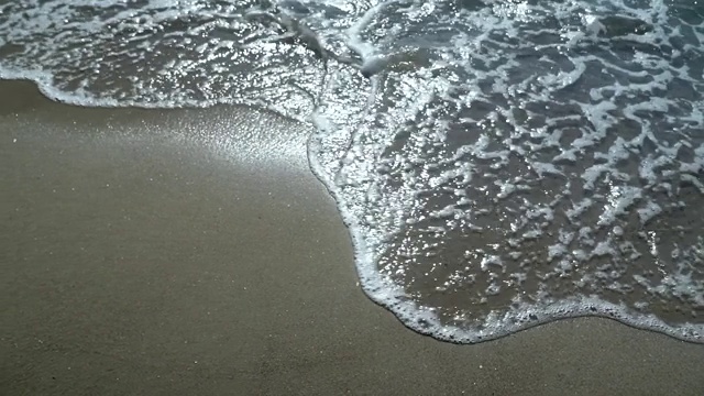 海滩，泡沫的海洋，海浪冲刷着沙子。海浪冲击着沙滩。海浪声视频素材