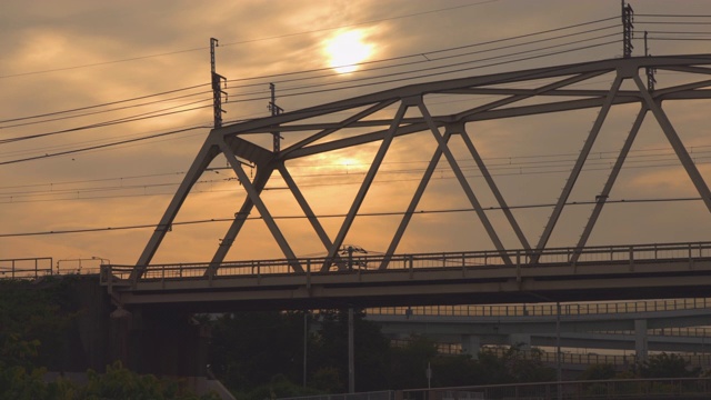 一列沐浴在夕阳中的火车穿过横滨郊区的一座铁路桥视频素材