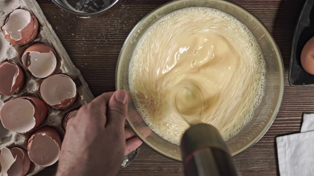 男人的手揉面团。制作美味佳肴或甜点的过程在桌子上烘焙的原料。在烹饪时，最好安排一张木桌。视频素材