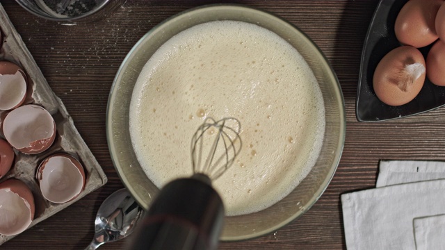 男人的手揉面团。制作美味佳肴或甜点的过程在桌子上烘焙的原料。在烹饪时，最好安排一张木桌。视频素材