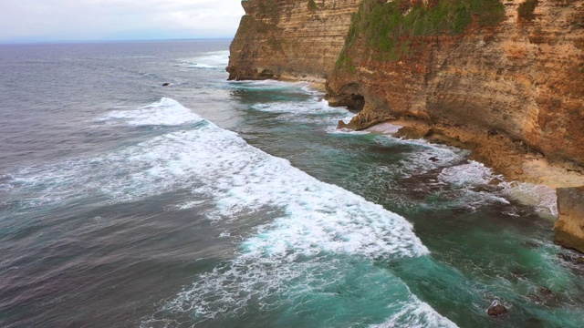 Uluwatu巴厘岛。蓝色的海洋和岩石山，覆盖着热带树木。视频素材