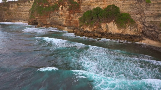 Uluwatu巴厘岛。蓝色的海洋和岩石山，覆盖着热带树木。视频素材