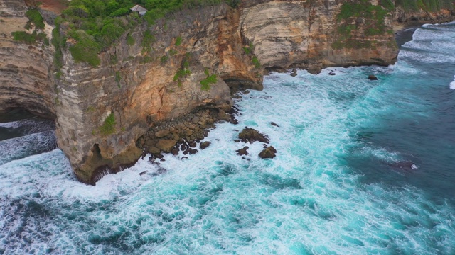 Uluwatu巴厘岛。蓝色的海洋和岩石山，覆盖着热带树木。视频素材