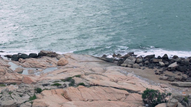 海石映衬着波涛汹涌的大海。海岸上的大石头视频素材