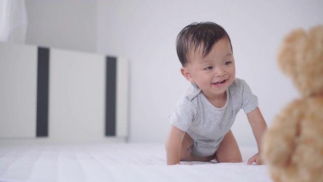 小男孩在床上爬，孩子们在玩耍和快乐的概念视频素材