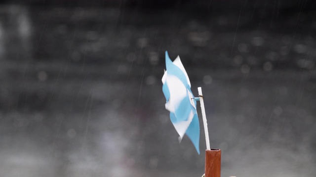 五颜六色的风向标旋转在一个单色背景，而下雨。视频素材