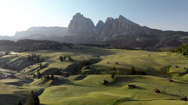 无人机在意大利Dolomites的Seiser Alm山谷和传统的木制山小屋上空飞行视频素材