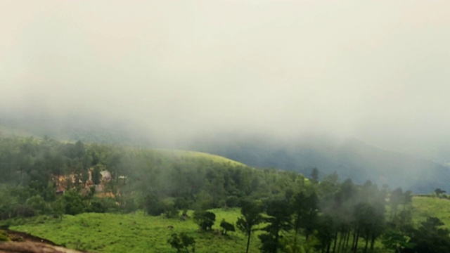 在喀拉拉邦，雾通过绿色草地的时间流逝与山脉的背景与文本动画空间。视频下载