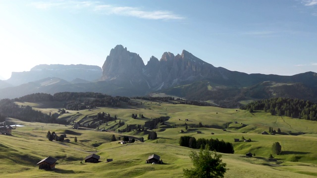 无人机在意大利Dolomites的Seiser Alm山谷和传统的木制山小屋上空飞行视频素材