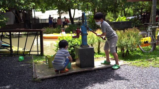 孩子们在玩手摇泵。视频下载