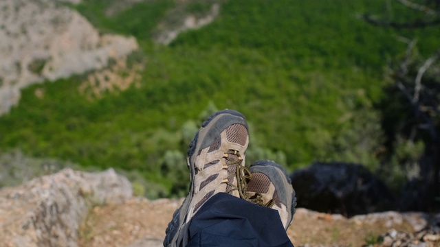 夏季时，山区自然全景景观。在前景穿靴子的徒步旅行者视频素材