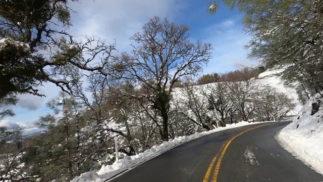 在一个阳光明媚的冬日，新雪覆盖着山坡，从汉密尔顿山顶开车下来;南旧金山海湾地区，加利福尼亚州视频下载