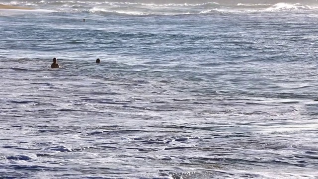 在夏威夷瓦胡岛上，海浪拍打着沙滩上一名身份确认的人视频素材