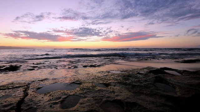 海浪拍打着夏威夷瓦胡岛日落海滩附近的岩石视频素材