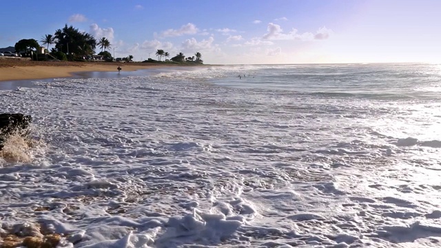 在夏威夷瓦胡岛上，海浪拍打着沙滩上一名身份确认的人视频素材