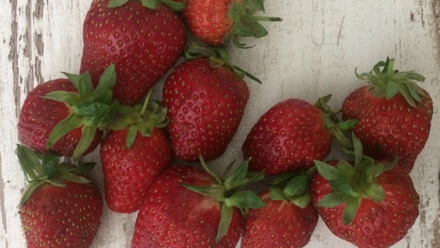 新鲜和有机草莓出现在木质桌子的顶部-停止运动视频素材