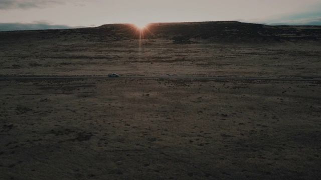 空中跟踪拍摄日落显示越野车行驶在一个偏远的土路，美国犹他州视频素材