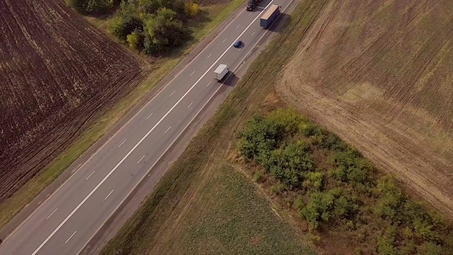 鸟瞰图货车。大型货车在移动。航拍美丽乡村公路上的卡车。春日田野道路上的半卡车鸟瞰图。视频素材