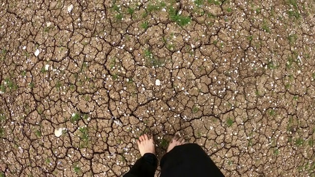 脚光着脚走在地上的裂缝和草上视频素材