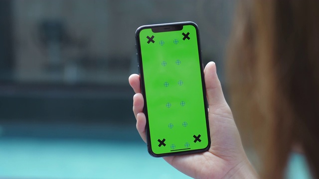 手持色度键的绿屏智能手机观看内容视频素材