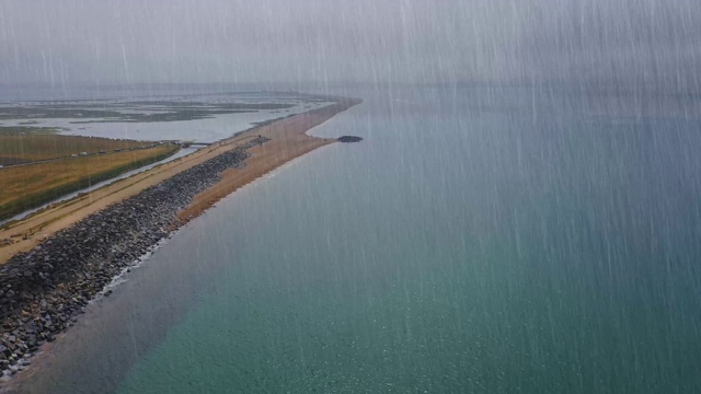 在伯恩茅斯海边的南悬崖上，一个阴冷潮湿的雨天，空中镜头在雨中飞行视频素材