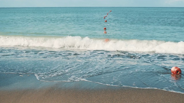 夏天的沙滩与迎面而来的海浪和红色浮标视频下载