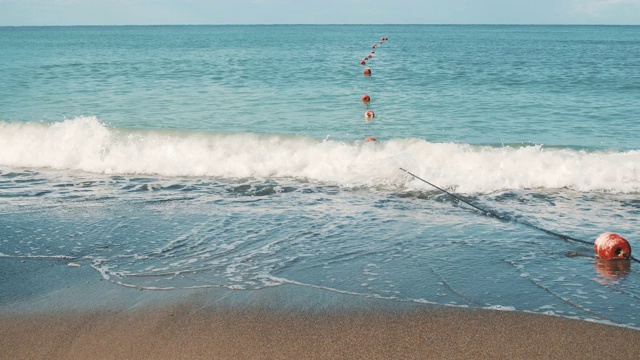 夏天的沙滩与迎面而来的海浪和红色浮标视频下载