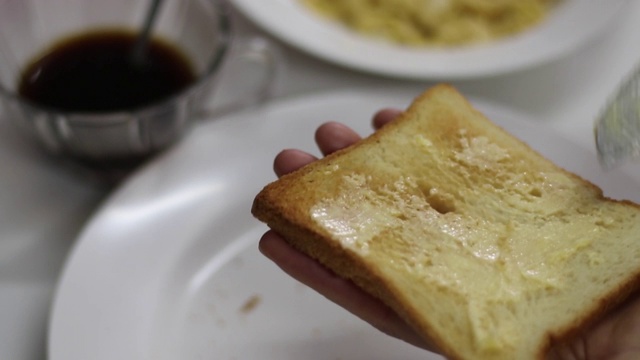 在面包上涂上黄油和炒鸡蛋视频素材