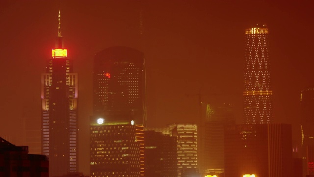 烟雾弥漫的夜晚，中国广州灯火辉煌的摩天大楼。视频素材