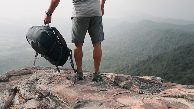 山谷风景的背包客。一个徒步旅行者来到山的边缘，把背包放在地上视频素材