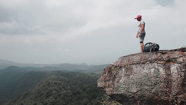 山谷风景的背包客。一个徒步旅行者来到了山的边缘，然后躺在了地上，背包当枕头用视频素材