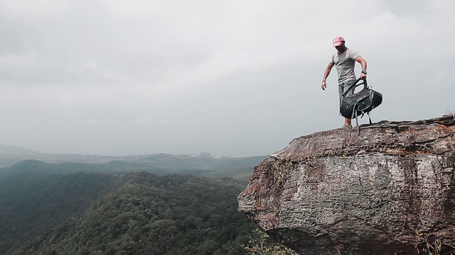 山谷风景的背包客。一个徒步旅行者来到了山的边缘，然后躺在了地上，背包当枕头用视频素材