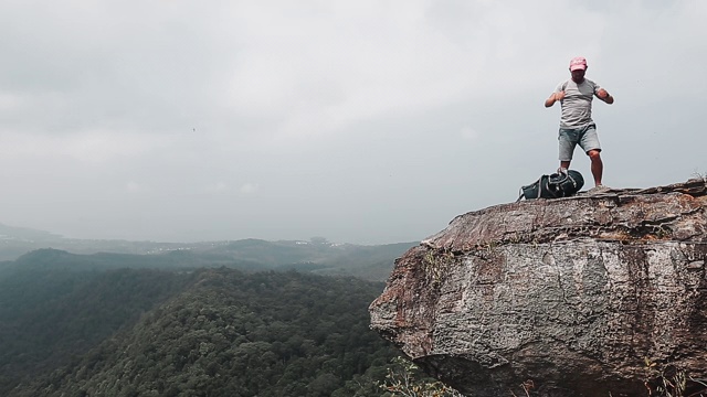 山谷风景的背包客。一名徒步旅行者在山边用背包当枕头休息，然后离开视频素材