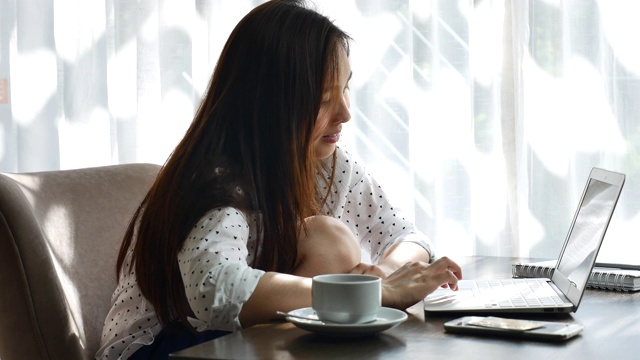 亚洲女性在家里使用笔记本电脑视频素材