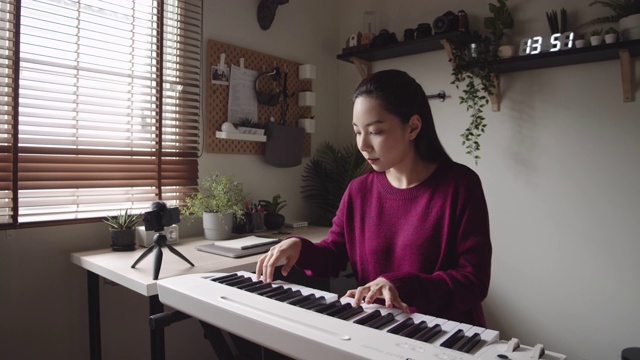 独自在家键盘钢琴爱好年轻女子用智能手机练习钢琴视频素材