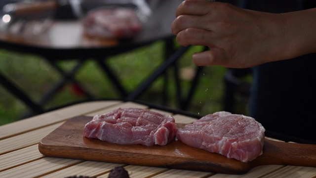 在户外露营时，在厚厚的猪肉牛排上加一层视频素材